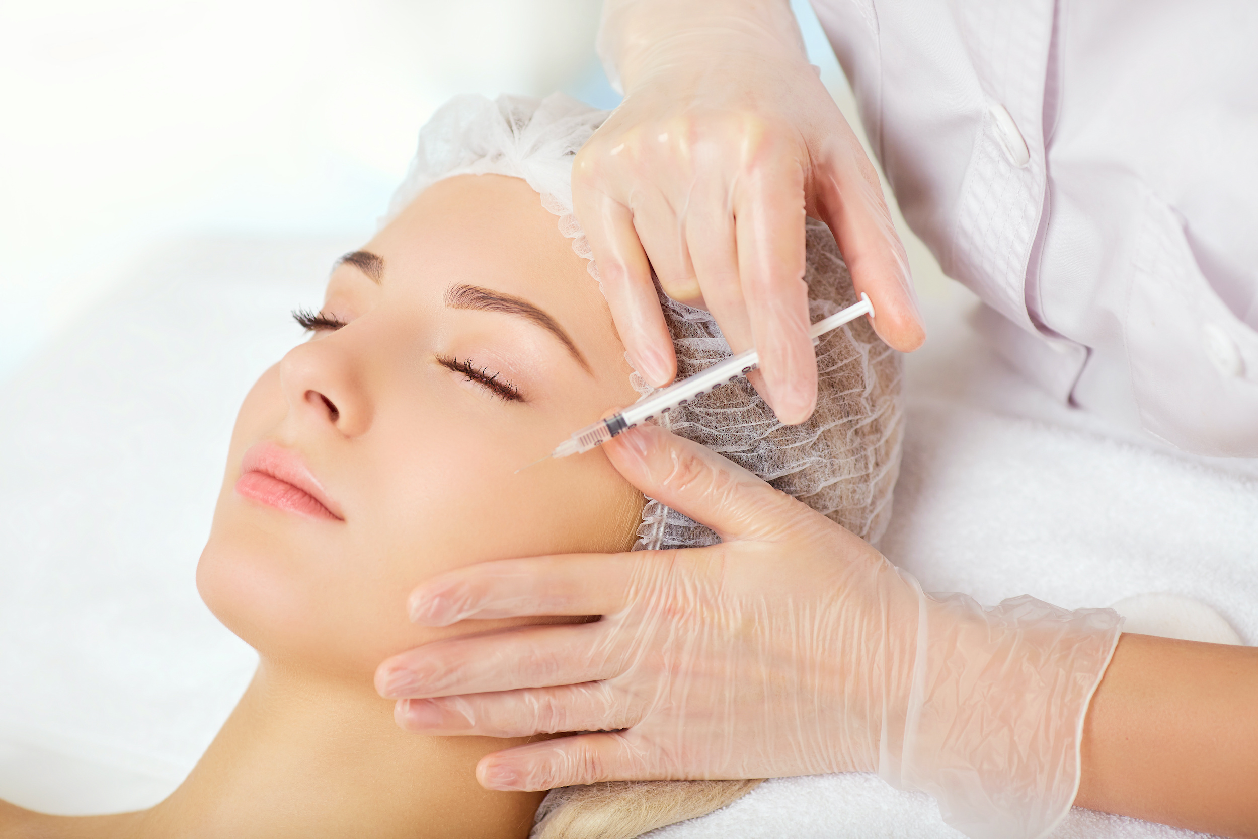 A woman receives an inejection on her face in the clinic.