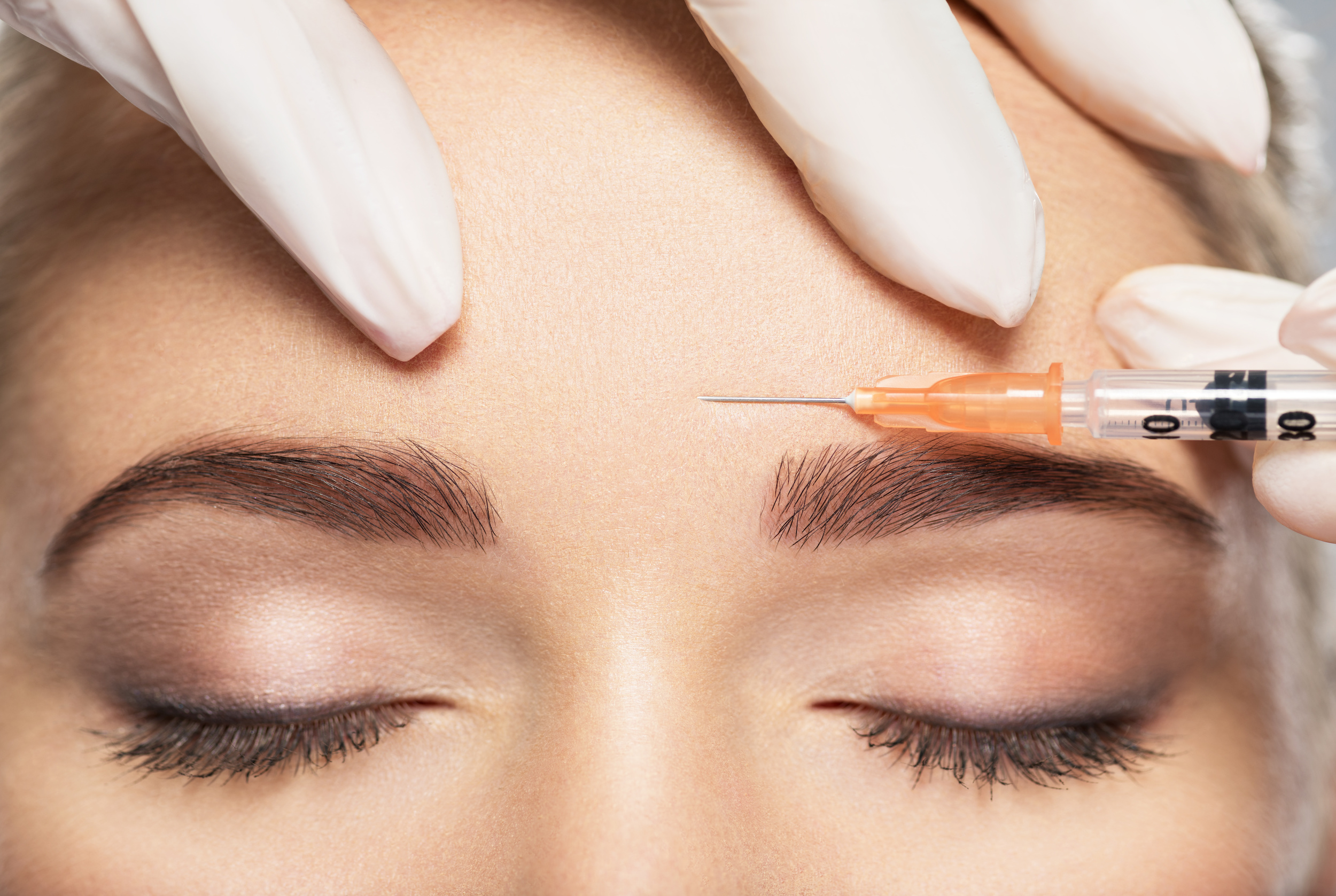 Woman getting cosmetic injection of botox near eyes, closup. Woman in beauty salon. plastic surgery clinic.